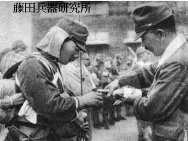 Un ufficiale dà del sake a un soldato prima di una missione